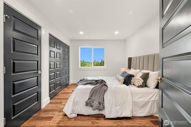 bedroom with a closet, recessed lighting, and light wood-type flooring