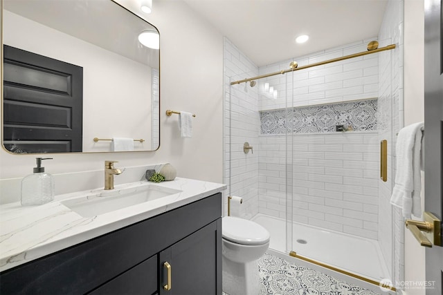 bathroom with toilet, vanity, and a stall shower