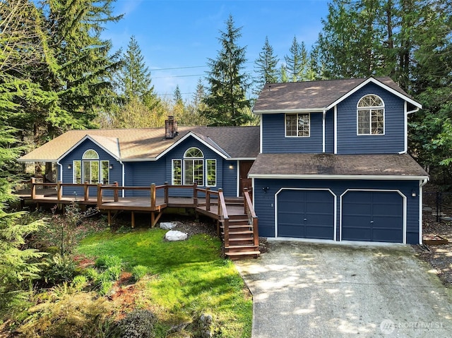 view of front facade with roof with shingles, driveway, a front lawn, a wooden deck, and a garage