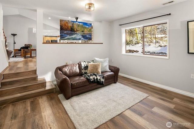 living area featuring stairs, baseboards, and wood finished floors