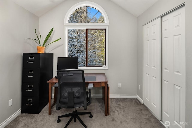 carpeted home office with baseboards and vaulted ceiling