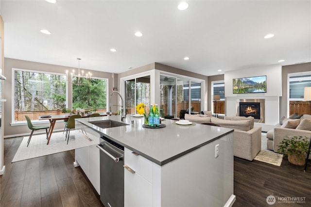 24014 Lily Pl SE, Black Diamond, WA 98010 - kitchen featuring a sink, a glass covered fireplace, dishwasher, a kitchen island with sink, and white cabinetry