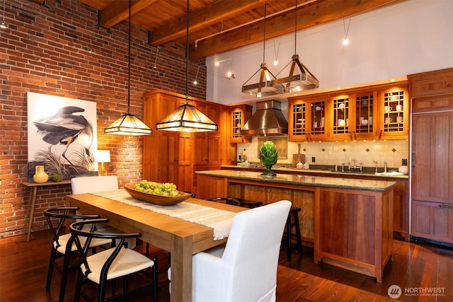 dining room featuring dark wood finished floors, a high ceiling, wood ceiling, beam ceiling, and brick wall
