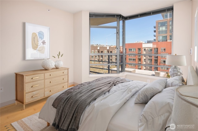 bedroom with light wood-type flooring and baseboards