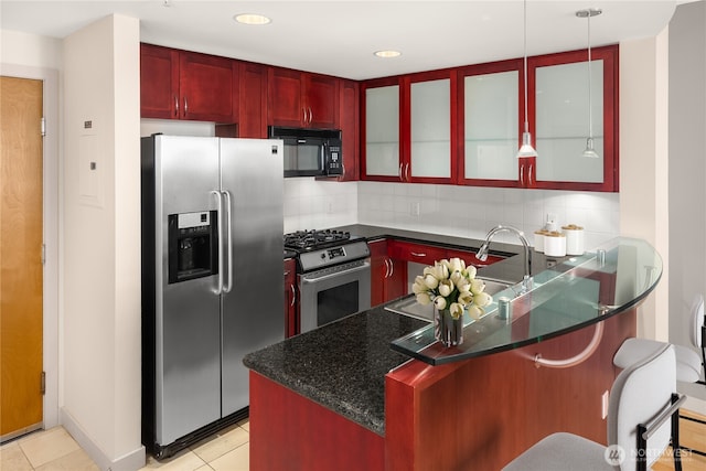 kitchen with decorative backsplash, light tile patterned flooring, reddish brown cabinets, and appliances with stainless steel finishes
