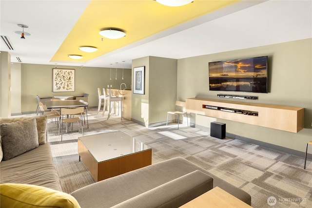 living area with baseboards and carpet