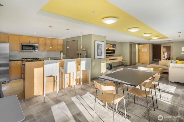 dining space featuring a raised ceiling and light tile patterned flooring