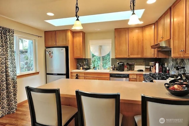 41 Rocky Ridge Dr, Bellingham, WA 98229 - kitchen featuring light countertops, tasteful backsplash, under cabinet range hood, a skylight, and appliances with stainless steel finishes