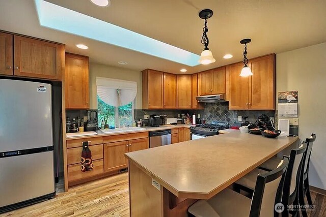 41 Rocky Ridge Dr, Bellingham, WA 98229 - kitchen featuring a sink, tasteful backsplash, hanging light fixtures, under cabinet range hood, and stainless steel appliances