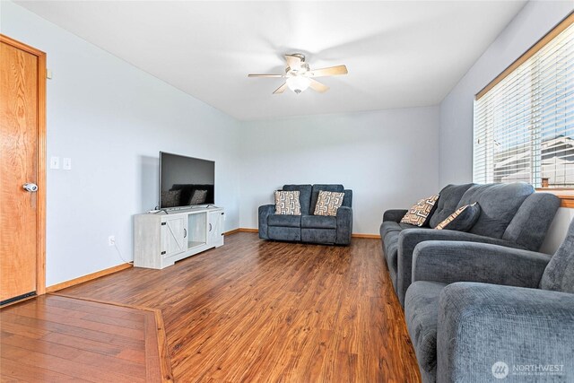living room with a ceiling fan, wood finished floors, and baseboards