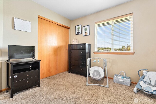 carpeted bedroom featuring a closet and baseboards