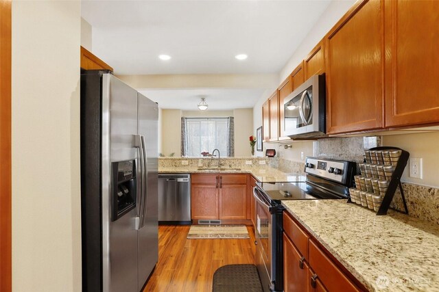 9423 18th Ave W Unit A, Everett, WA 98204 - kitchen featuring appliances with stainless steel finishes, a sink, light stone counters, light wood-style flooring, and recessed lighting