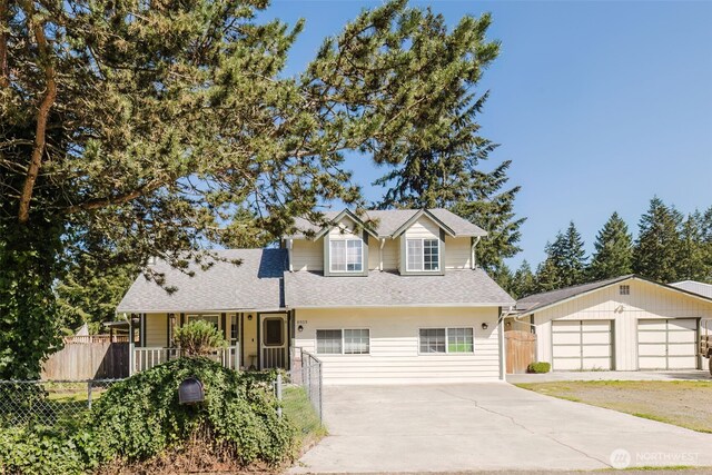 traditional-style home featuring covered porch, driveway, fence, and roof with shingles