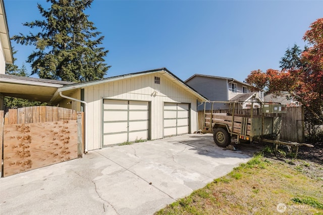 view of side of home with concrete driveway, fence, and a garage