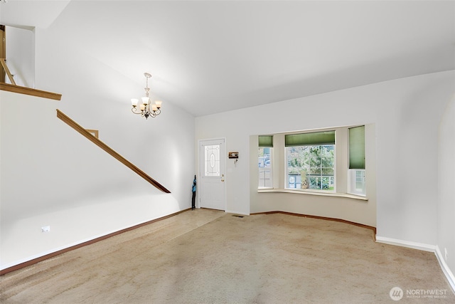entrance foyer featuring a chandelier, carpet floors, and a healthy amount of sunlight