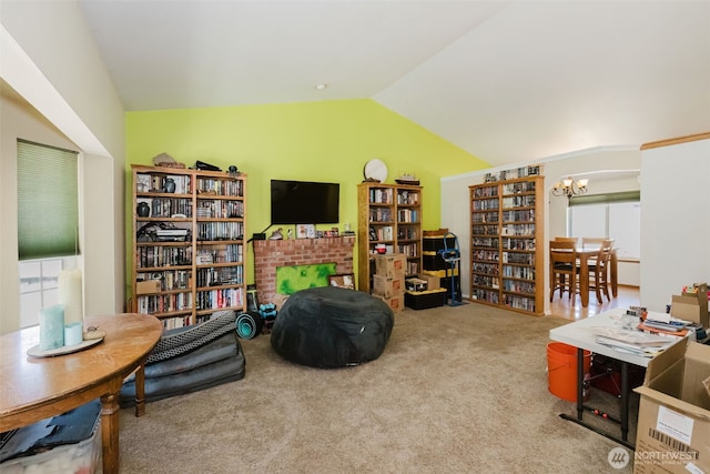 living area featuring lofted ceiling, carpet floors, and a notable chandelier