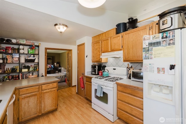 kitchen with decorative backsplash, white appliances, light wood-type flooring, light countertops, and under cabinet range hood
