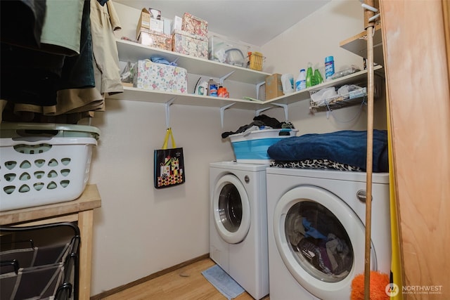 laundry area with light wood-style flooring, baseboards, independent washer and dryer, and laundry area