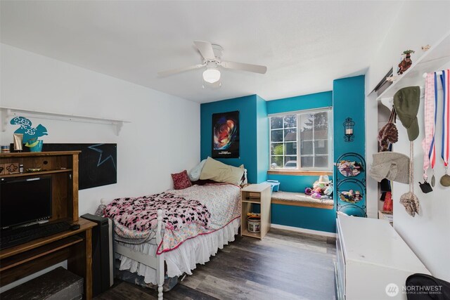 bedroom with ceiling fan, baseboards, and wood finished floors