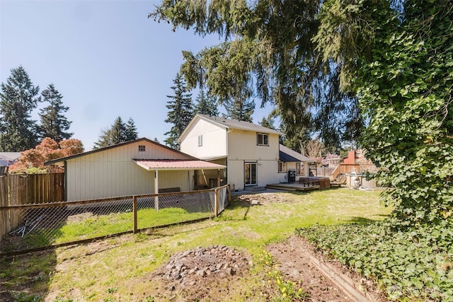 rear view of property featuring a fenced backyard and a yard