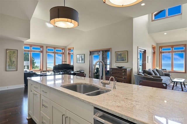 9535 Semiahmoo Pkwy Unit B305, Blaine, WA 98230 - kitchen featuring a sink, white cabinetry, stainless steel dishwasher, open floor plan, and lofted ceiling