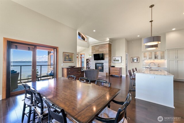 9535 Semiahmoo Pkwy Unit B305, Blaine, WA 98230 - dining room featuring high vaulted ceiling, a fireplace, dark wood finished floors, a water view, and recessed lighting