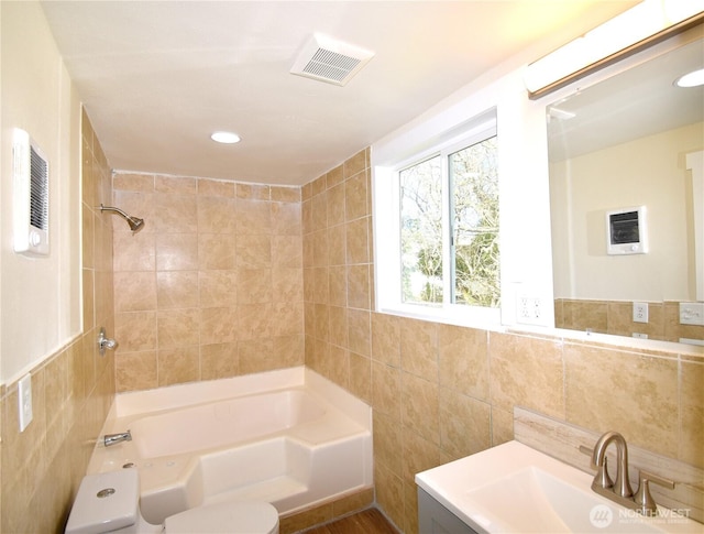 full bath with visible vents,  shower combination, toilet, and tile walls