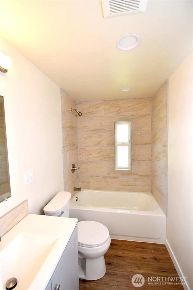 bathroom featuring vanity, shower / bath combination, toilet, visible vents, and wood finished floors