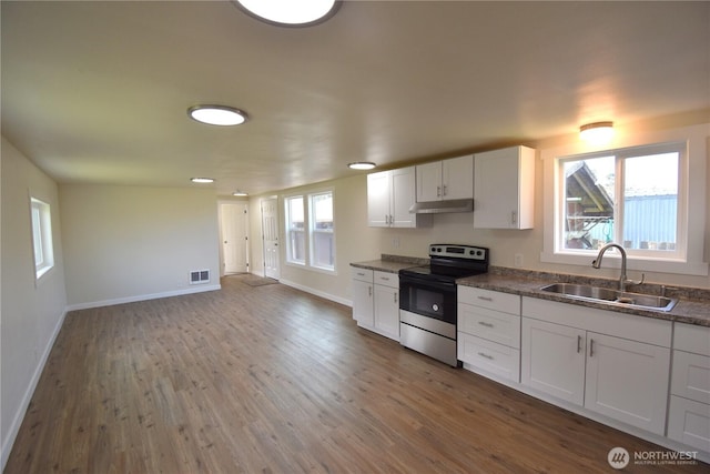 kitchen featuring visible vents, wood finished floors, under cabinet range hood, a sink, and stainless steel electric stove
