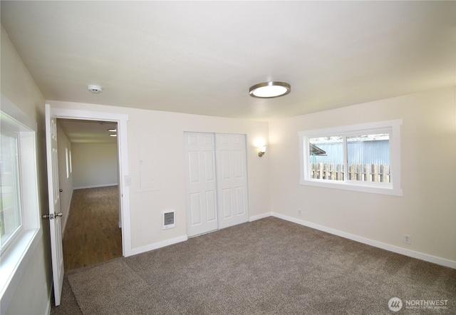 unfurnished bedroom featuring baseboards, carpet, a closet, and visible vents