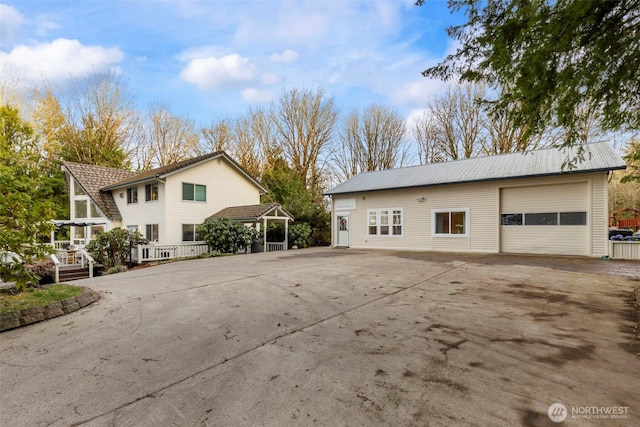 exterior space with a garage and metal roof