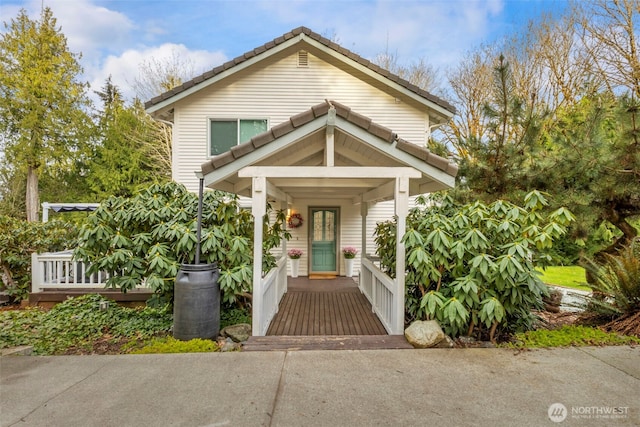 view of front of property featuring a tiled roof and covered porch