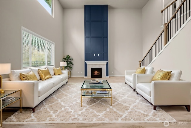 32904 SE Stevens St, Black Diamond, WA 98010 - living room featuring baseboards, a fireplace, wood finished floors, and a towering ceiling