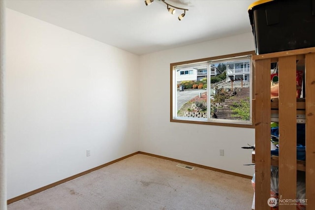 empty room with carpet, baseboards, and visible vents