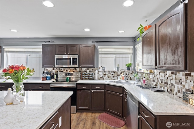 13328 67th Ave E, Puyallup, WA 98373 - kitchen featuring a wealth of natural light, a sink, wood finished floors, appliances with stainless steel finishes, and dark brown cabinets