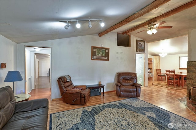 living room featuring wood finished floors, a ceiling fan, and lofted ceiling with beams
