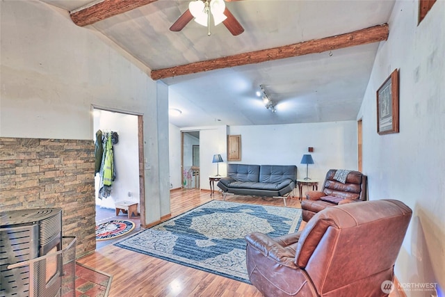 living room featuring a ceiling fan, wood finished floors, and lofted ceiling with beams