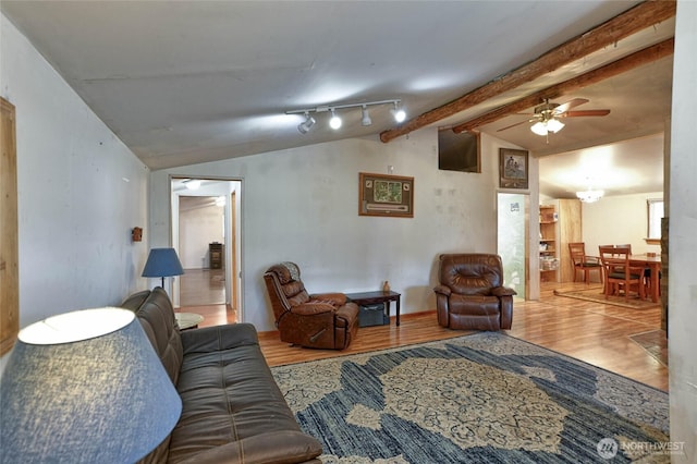 living area featuring ceiling fan, wood finished floors, and lofted ceiling with beams