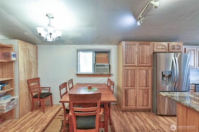 dining space with cooling unit, a notable chandelier, light wood-type flooring, and track lighting