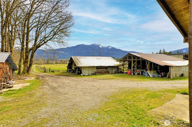 view of yard featuring an outdoor structure, a mountain view, and an outbuilding