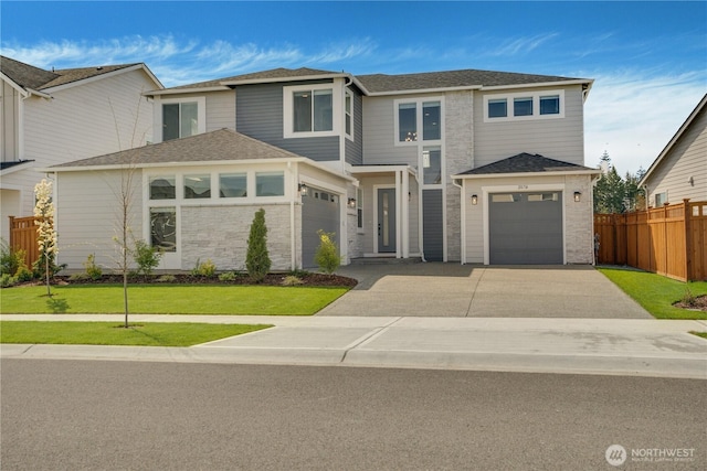 view of front of home with fence, a shingled roof, an attached garage, driveway, and a front yard