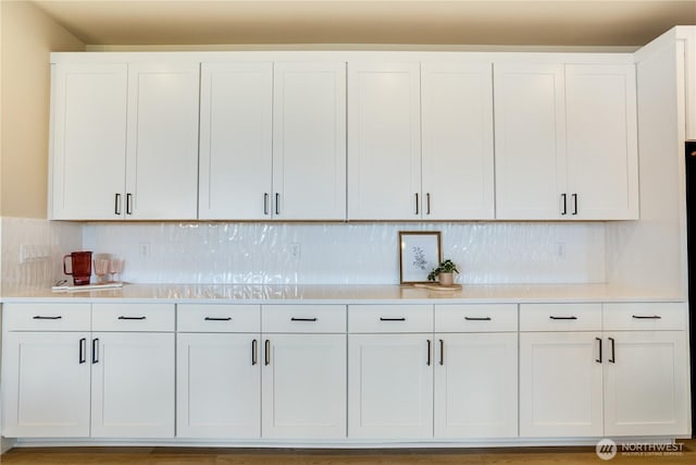 kitchen with white cabinets, decorative backsplash, and light countertops