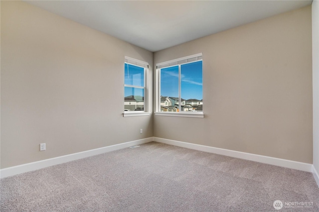 spare room with baseboards and carpet flooring