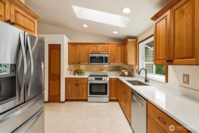1129 235th Pl SW, Bothell, WA 98021 - kitchen featuring appliances with stainless steel finishes, a skylight, a sink, vaulted ceiling, and brown cabinets