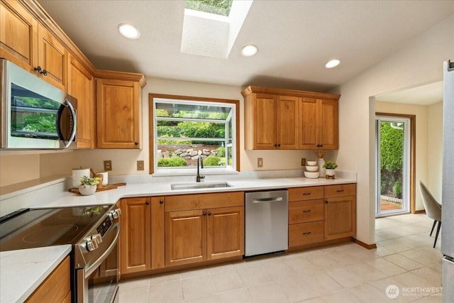 1129 235th Pl SW, Bothell, WA 98021 - kitchen featuring stainless steel appliances, a sink, a skylight, light countertops, and brown cabinets