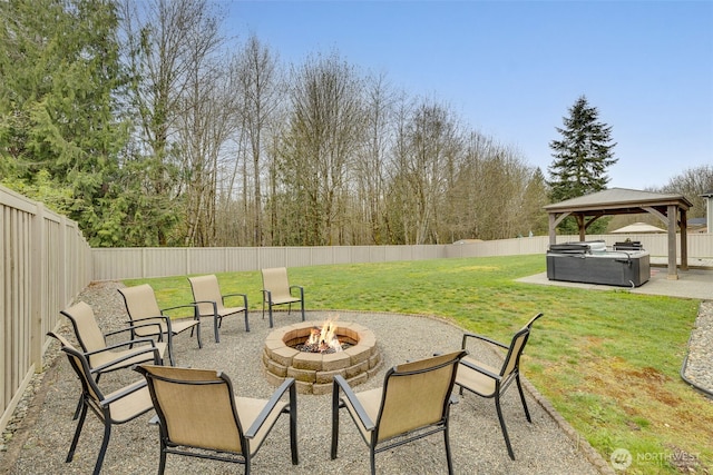 view of patio / terrace with an outdoor fire pit, a gazebo, a fenced backyard, and a hot tub