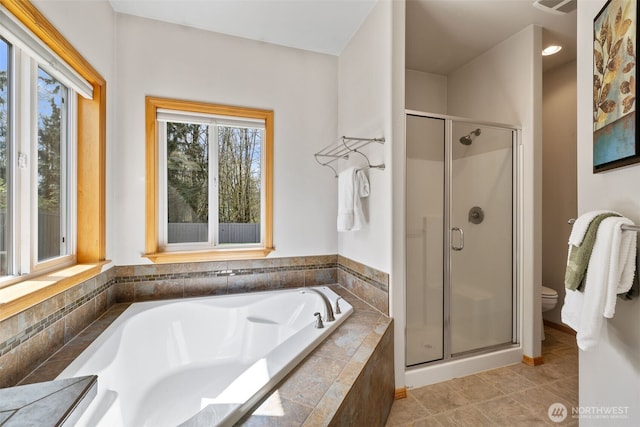 full bathroom featuring a bath, tile patterned floors, toilet, and a stall shower