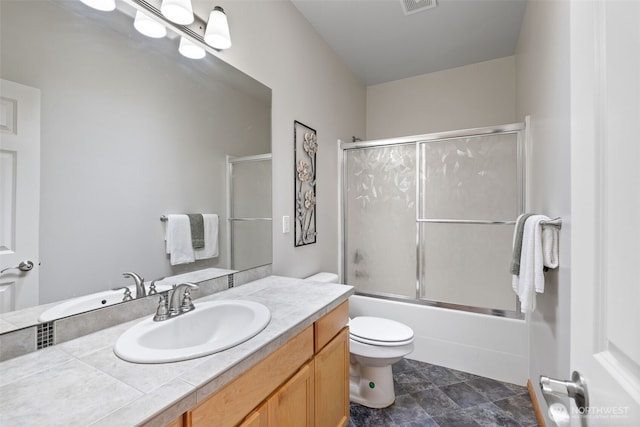 bathroom with combined bath / shower with glass door, toilet, vanity, and visible vents