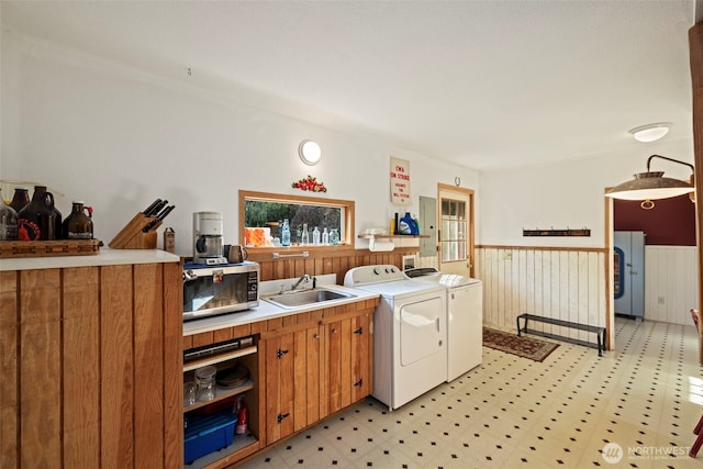 3404 Oysterville Rd, Oysterville, WA 98641 - laundry area featuring wainscoting, washing machine and clothes dryer, a sink, laundry area, and light floors