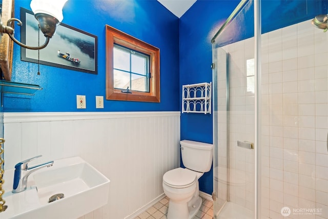 3404 Oysterville Rd, Oysterville, WA 98641 - bathroom featuring toilet, a sink, a stall shower, and wainscoting
